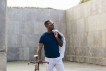 Hombre negro de moda con bicicleta - foto de stock