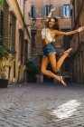Подтянутая девушка, прыгающая на улице — стоковое фото