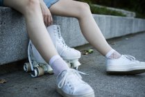 Crop girl in sneakers with roller skates — Stock Photo