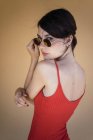 Menina de corpo vermelho desgaste e óculos de sol posando — Fotografia de Stock