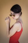 Дівчина в червоному одязі і сонцезахисні окуляри позує — стокове фото