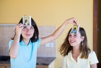 Girls playing game with photos — Stock Photo