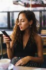 Девушка в кафе с телефоном — стоковое фото