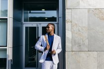 Content stylish man with phone in downtown — Stock Photo