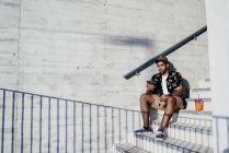 Fröhlicher Mann benutzt Smartphone auf Treppe — Stockfoto