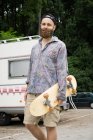 Man standing with skateboard — Stock Photo