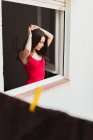 Gentle girl standing in window — Stock Photo