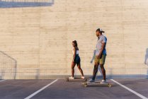 Casal andar de skate na rua — Fotografia de Stock