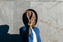 Homem fechando rosto com chapéu — Fotografia de Stock