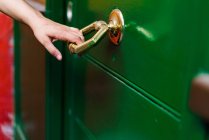 Cortar mão segurando maçaneta da porta — Fotografia de Stock
