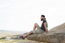 Homme relaxant sur la falaise — Photo de stock