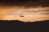 Small plane flying in sunset — Stock Photo