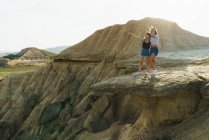 Возбужденные женщины, стоящие на скале — стоковое фото
