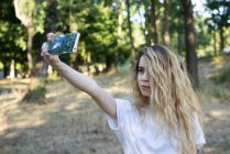 Girl taking selfie on landscape — Stock Photo