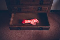 Dall'alto vista di taglio a mano insanguinata nel cassetto in legno . — Foto stock