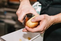 Close up view of male hands peeling potato — Stock Photo