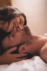 Retrato de mulher beijando namorado sonolento — Fotografia de Stock
