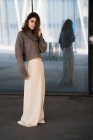 Femme attrayante posant en jupe et pull et regardant la caméra . — Photo de stock
