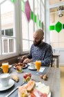 Retrato de homem barbudo tomando café da manhã no bistrô — Fotografia de Stock