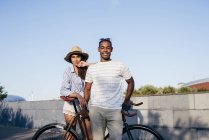 Casal inclinado na bicicleta e olhando para a câmera — Fotografia de Stock