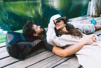 Paar liegt auf Holzsteg am See — Stockfoto