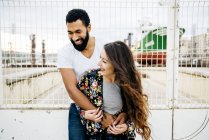 Laughing couple posing near wharf fence — Stock Photo