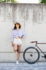 Girl in hat standing nearbike — Stock Photo