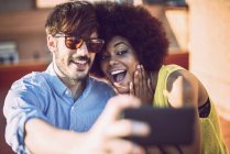 Cheerful young interracial couple taking selfie — Stock Photo