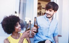 Happy multiracial friends clinking beers — Stock Photo