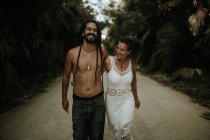 Ritratto di coppia ridente che abbraccia e cammina nel vicolo nei boschi tropicali . — Foto stock
