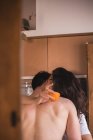 Mulher segurando laranja e abraçando namorado com paixão . — Fotografia de Stock