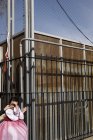 BARCELONA, SPAGNA - 10 luglio, 2011: Crop mano consolante ragazza in costume mentre in piedi vicino alla recinzione di metallo . — Foto stock