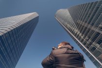 Homme prenant des photos de gratte-ciel dans le centre financier — Photo de stock