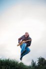 Експресивний чоловік з електричною гітарою в повітрі — стокове фото