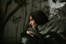 Bruna donna in posa in foglie verdi — Foto stock