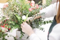 Close-up de mãos femininas fazendo arranjo floral na loja de flores — Fotografia de Stock