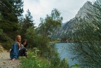 Fröhliche Frauen sitzen am See — Stockfoto