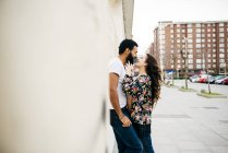 Paar lehnt an Mauer an Straße — Stockfoto
