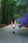 Mujer caminando con antorcha de humo - foto de stock