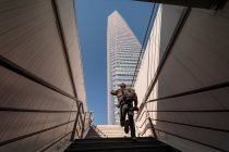 Человек поднимается по лестнице, чтобы поторопить небоскреб — стоковое фото