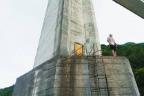 Uomo in posa sulla vecchia torre di cemento — Foto stock