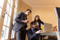 Group of people in suits attentively watching in laptop. — Stock Photo