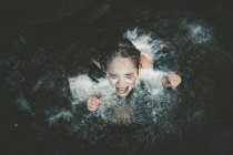 Girl with milk on face swimming out of well — Stock Photo
