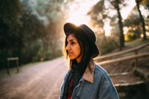 Brunette woman in hat at countryside road — Stock Photo