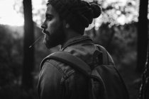 Человек, оглядывающийся через плечо в осеннем лесу — стоковое фото