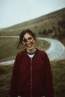 Smiling woman with messy hair at asphalt road in countryside. — Stock Photo