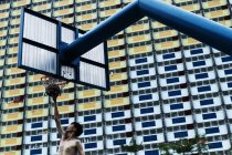 KAULA LUMPUR, MALASIA 2 APRILE, 2016: Dal basso tiro di uomo che gioca a basket sullo sfondo del condominio . — Foto stock