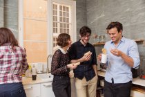 Young people eating and having fun at office kitchen. — Stock Photo