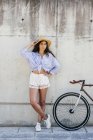 Girl in hat posing near bike — Stock Photo