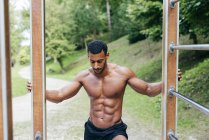 Muscular man posing in park — Stock Photo